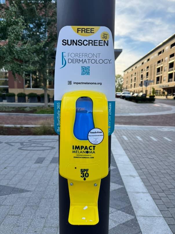 Free sunscreen dispenser offering SPF 30, provided by Forefront Dermatology and Impact Melanoma.