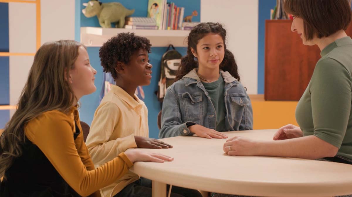 Teacher instructing young children around a table in a classroom