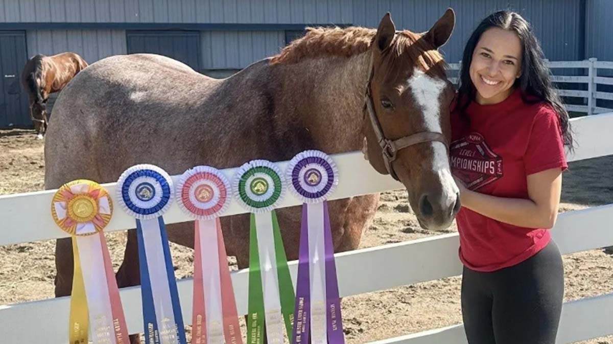 Marian University student posing with a horse