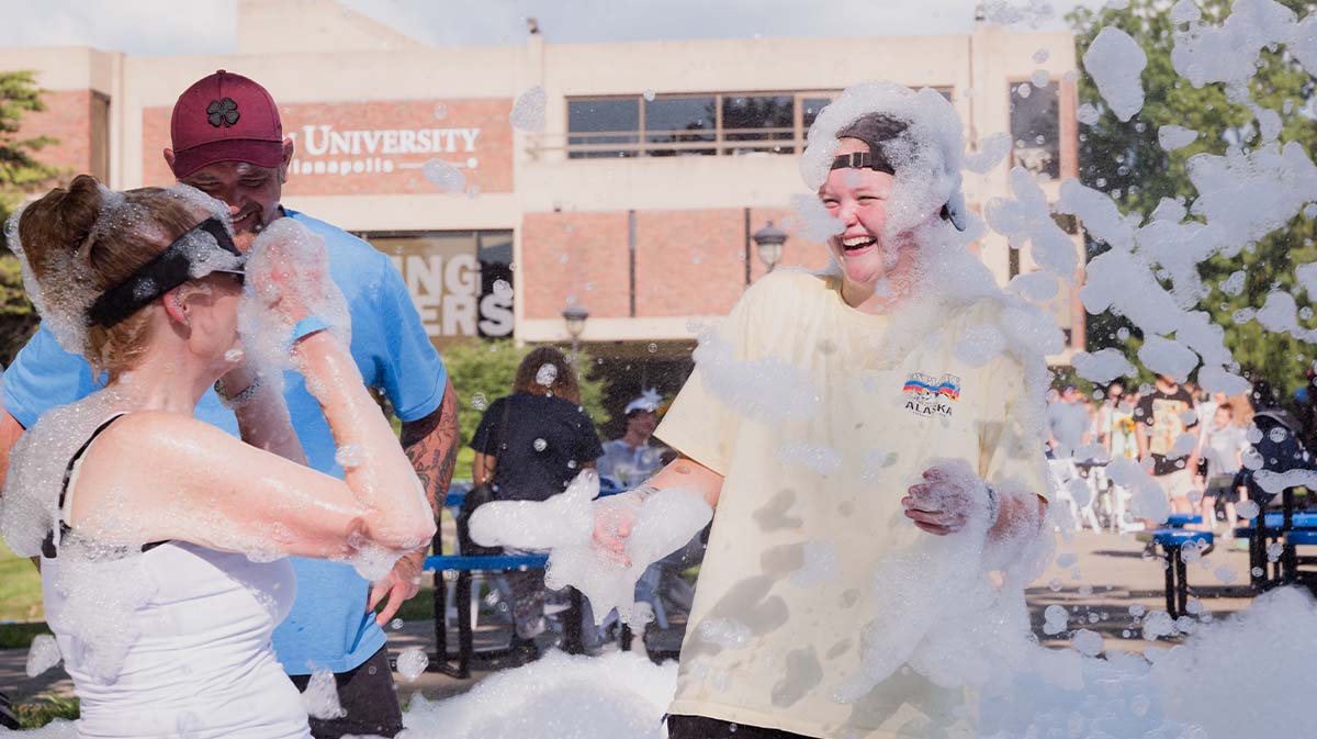 Students playing outside with bubbles and foam