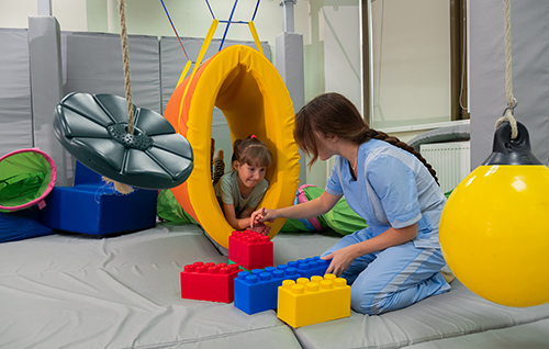 healthcare worker on the floor playing with little girl