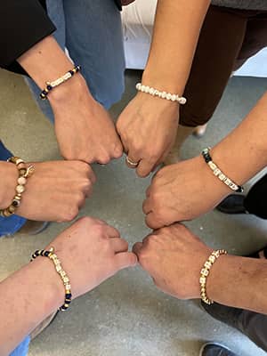 cropped image of fists showing handmade bracelets. 