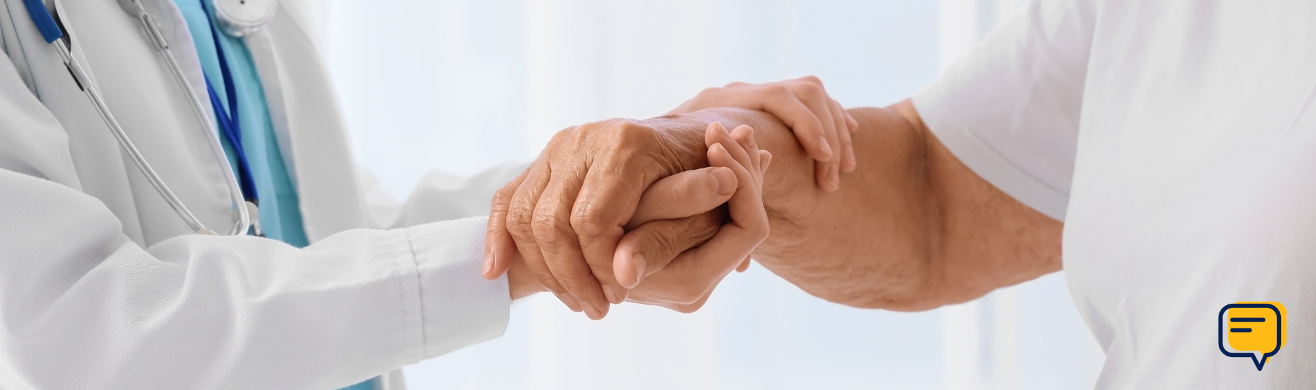 Image of a doctor in a white coat holding the hand of a patient