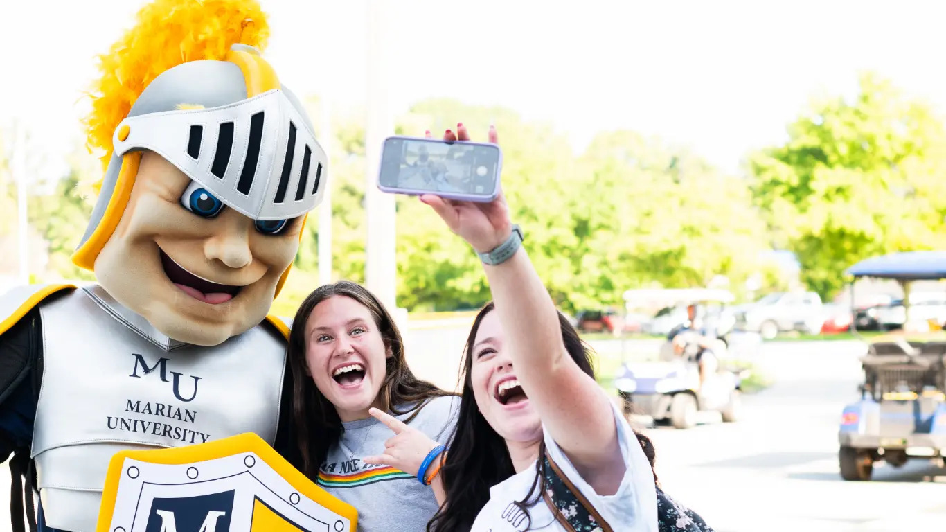 Students taking picture with Marian Mascot