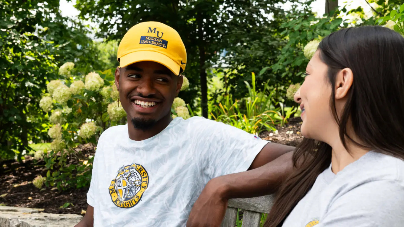 Student smiling on bench