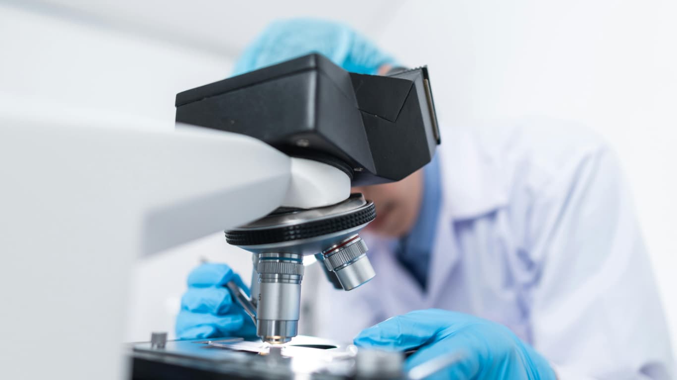 Biology Student looking into microscope