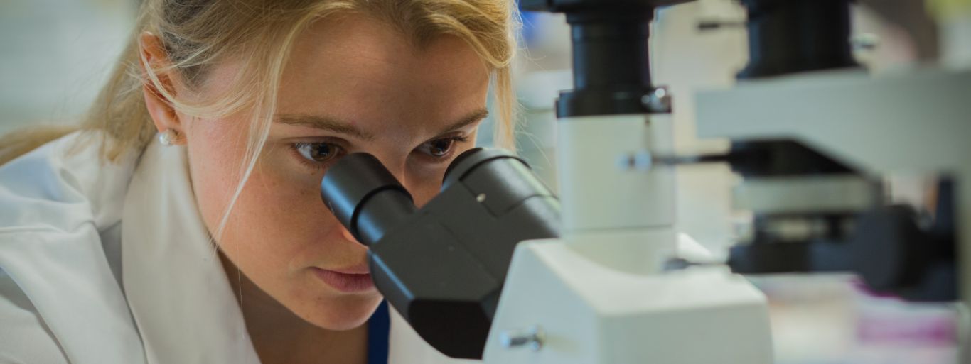 Med student looking into microscope