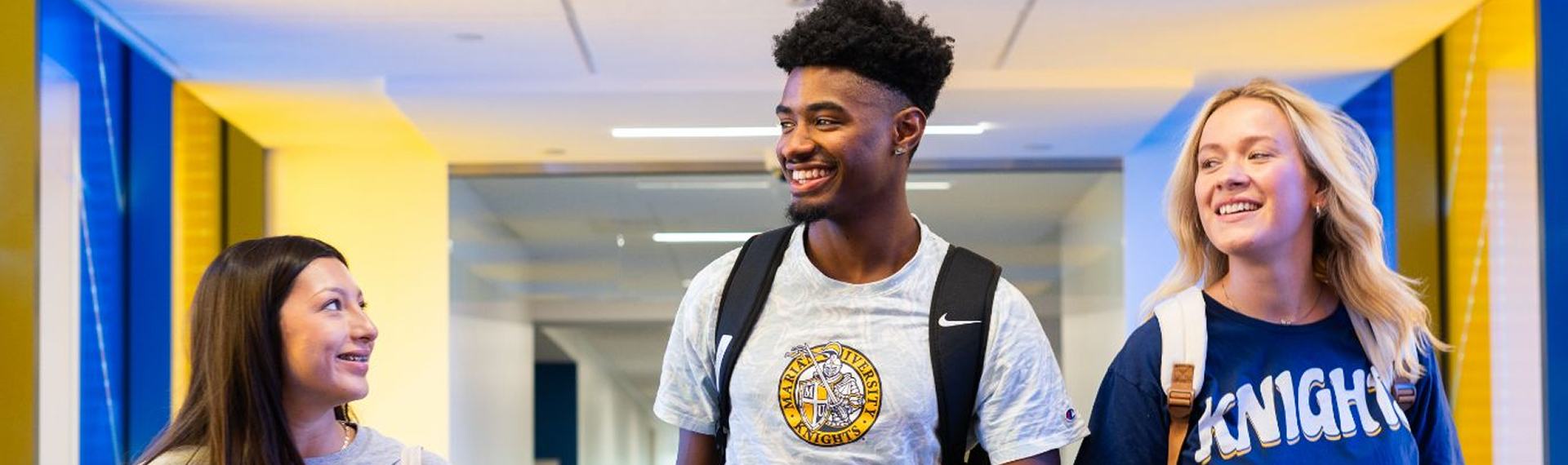 Students walking down hallway smiling