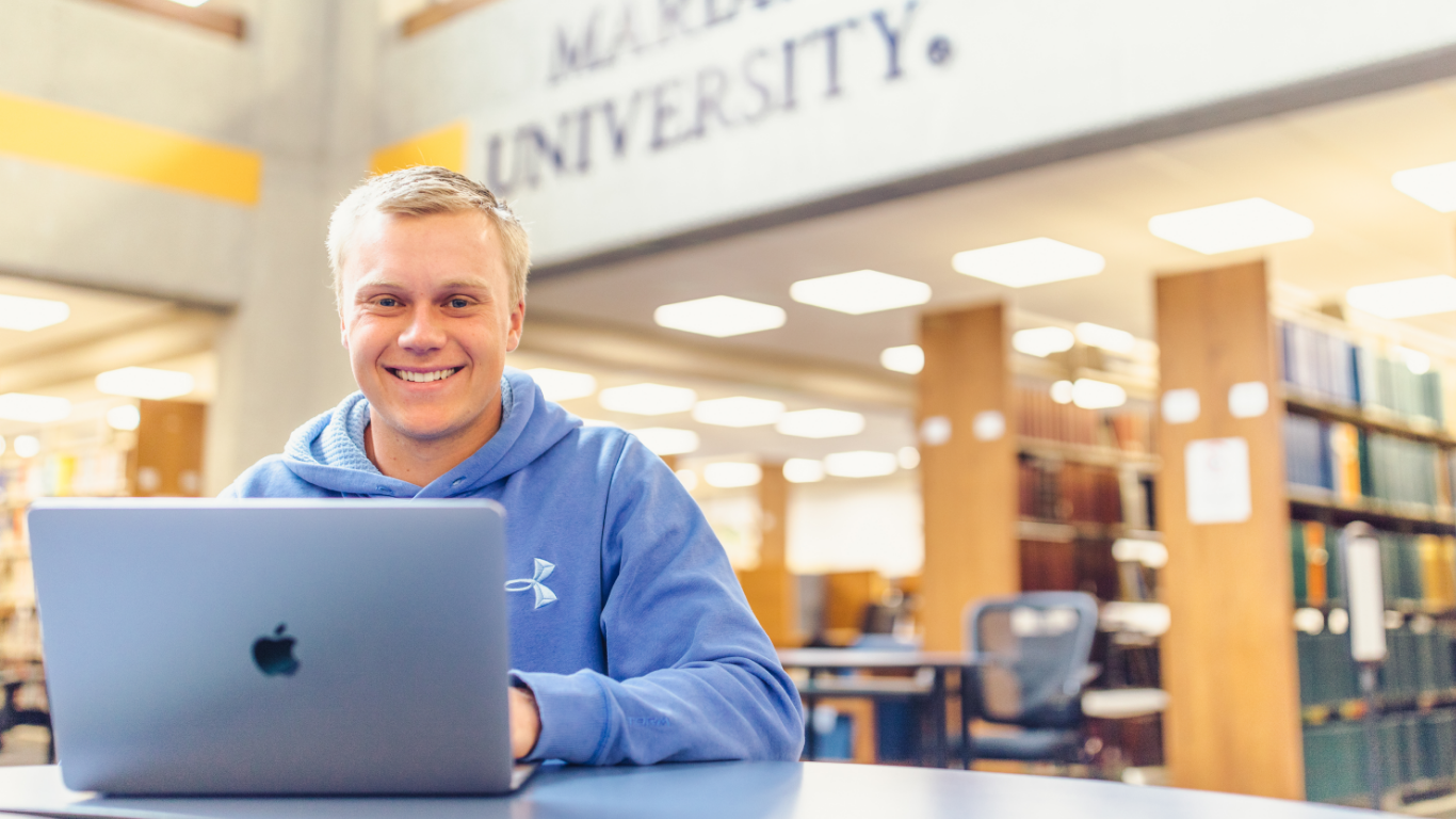 Student smiling in the library