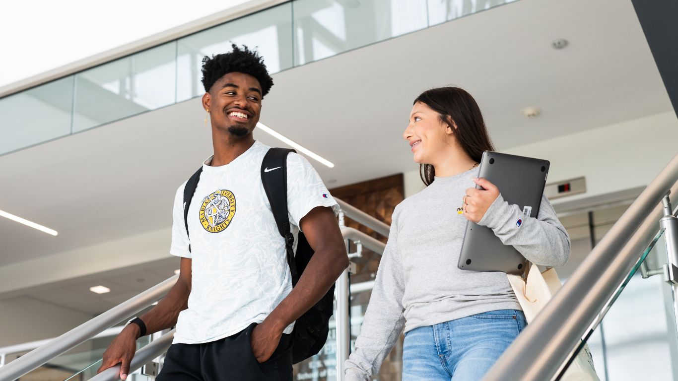 Students talking and walking down the stairs