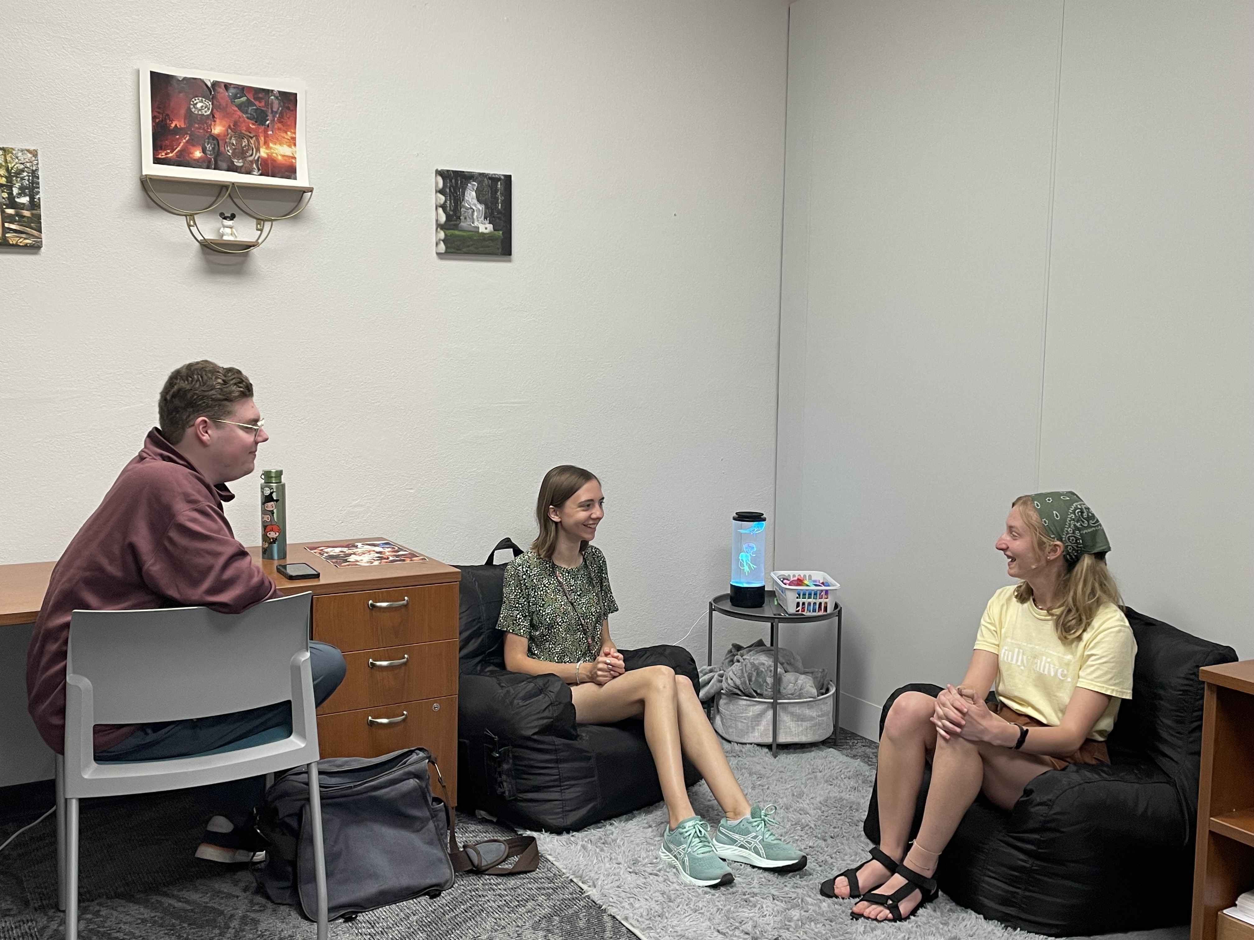 Three friends sitting in a cozy room, engaged in conversation...