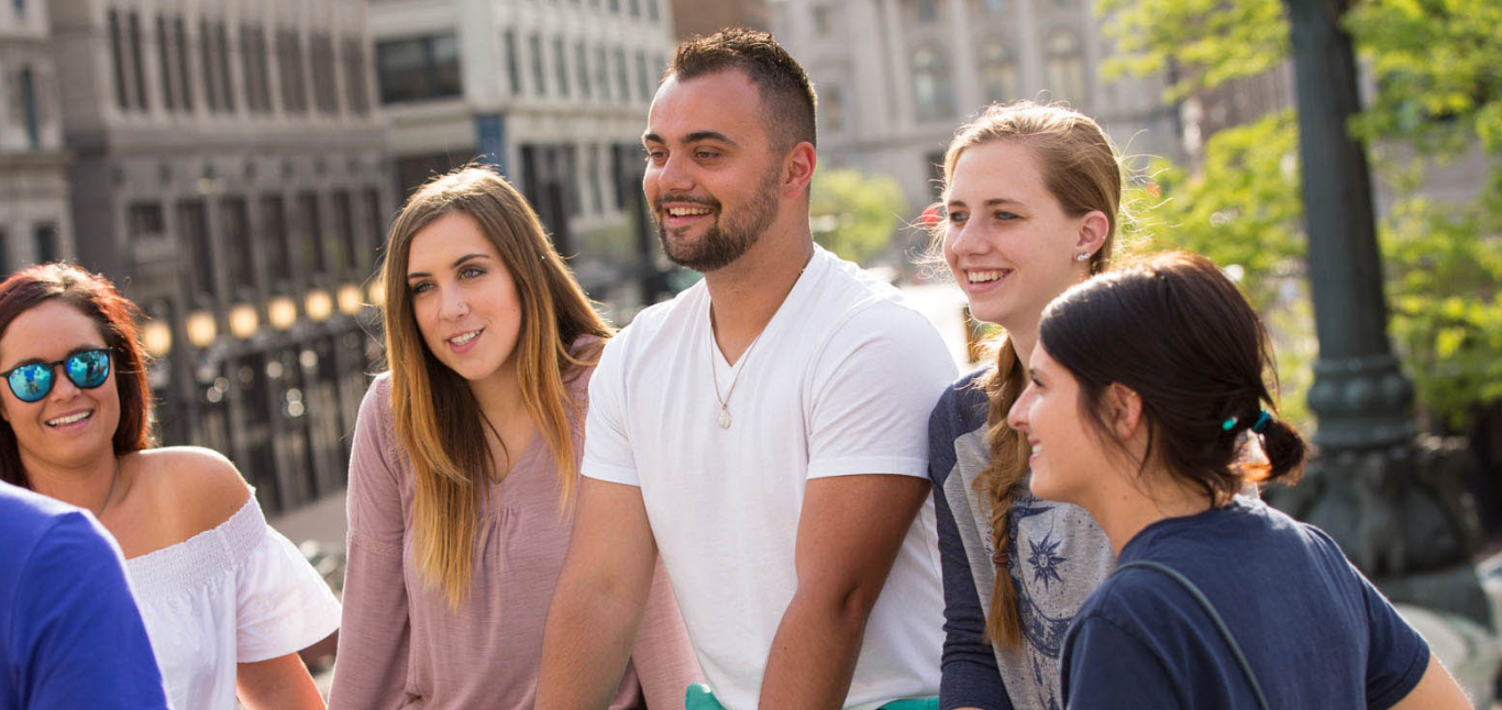 Students sitting outside in a city