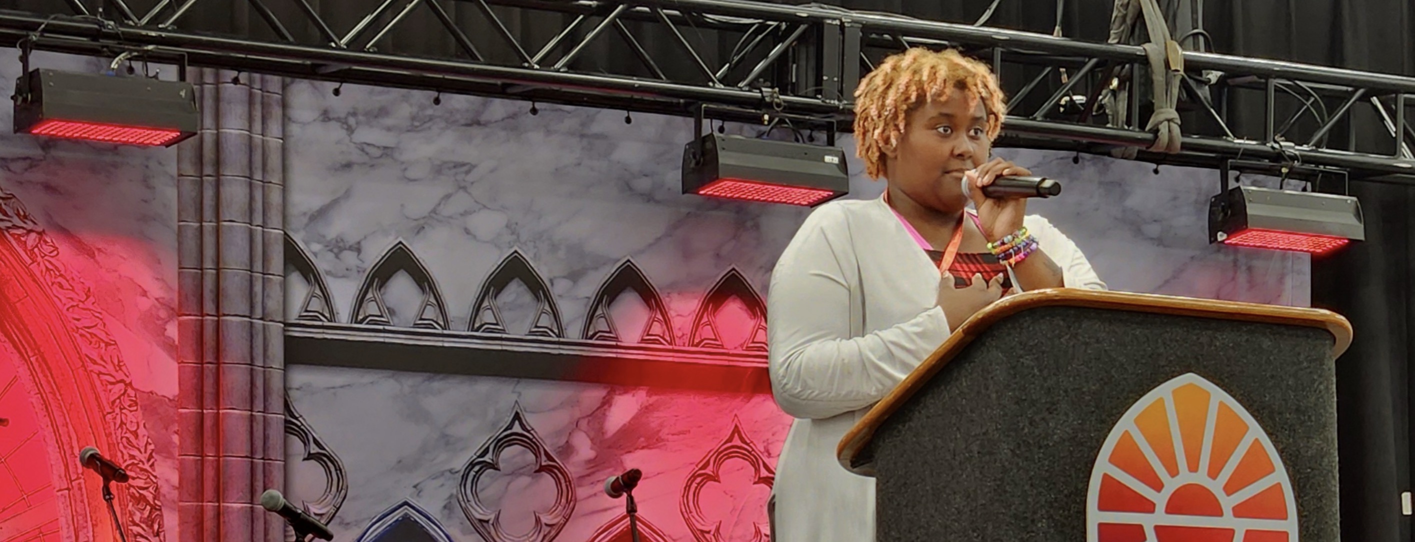 A student preaching with a microphone at a podium