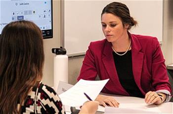 Two female graduate students working in classroom