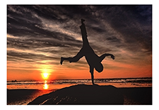 One handed hand stand at sunset on beach