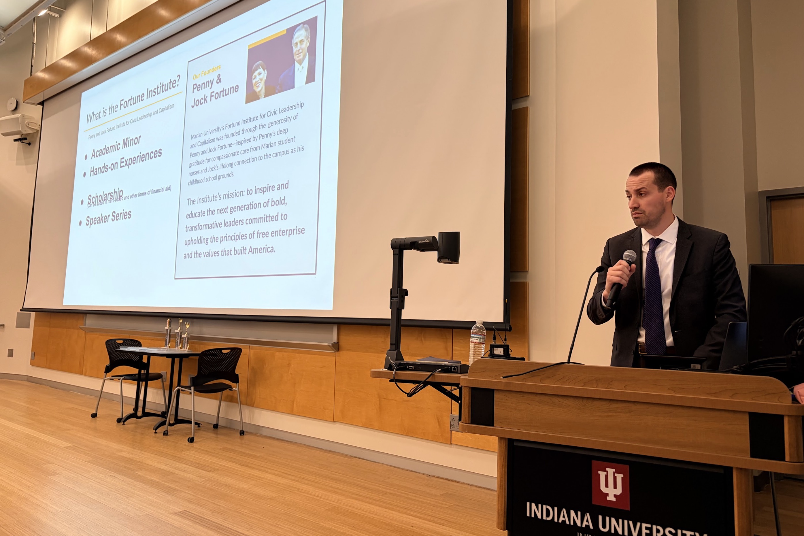 Speaker presenting information about the Fortune Institute at Indiana University, highlighting academic minors and speaker series.
