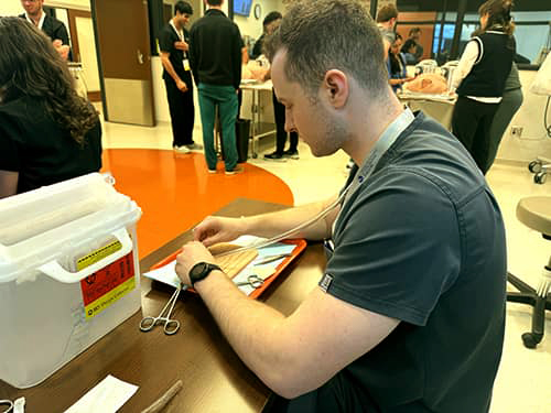 medical student at suture workshop